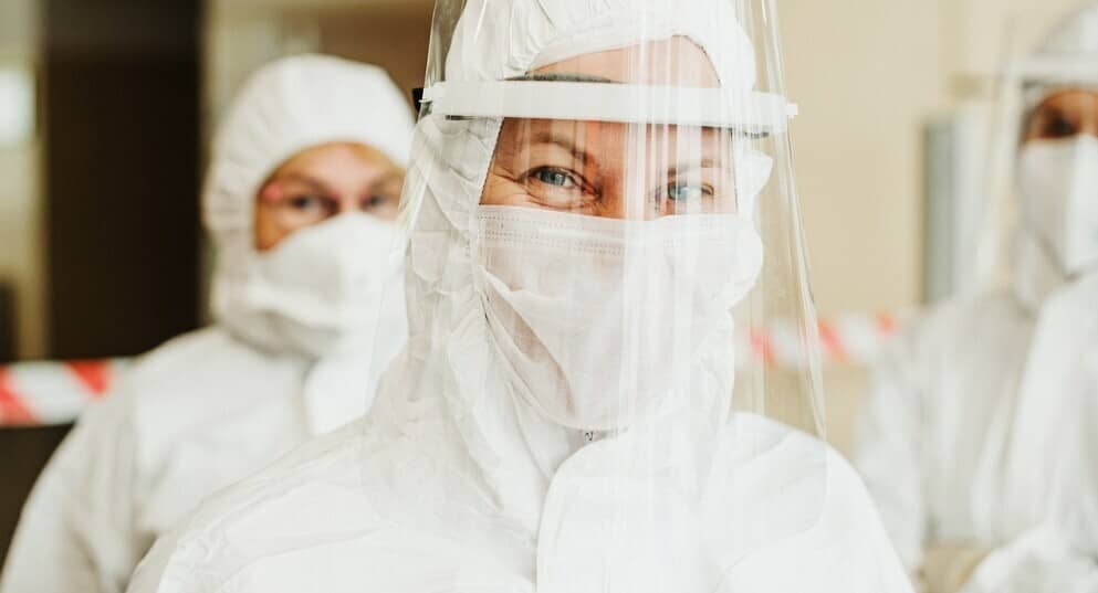 a woman wearing a face mask and protective gear for public protection.